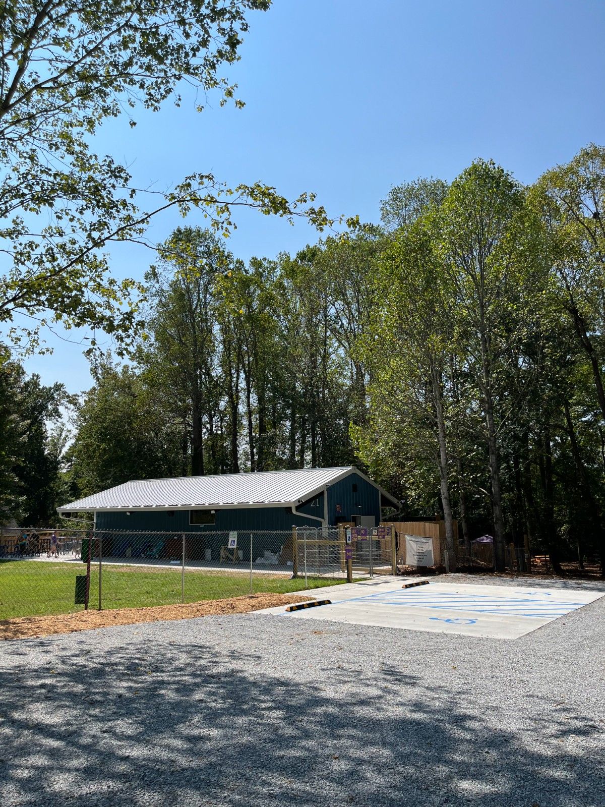 Large blue commercial storage building with a white metal roof and adjacent gravel parking lot, completed by a2-painting-commercial-in-hendersonville-nc.