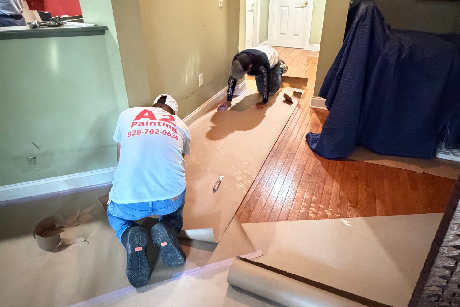 A2 Painting crew in branded shirts prepping an interior for paint