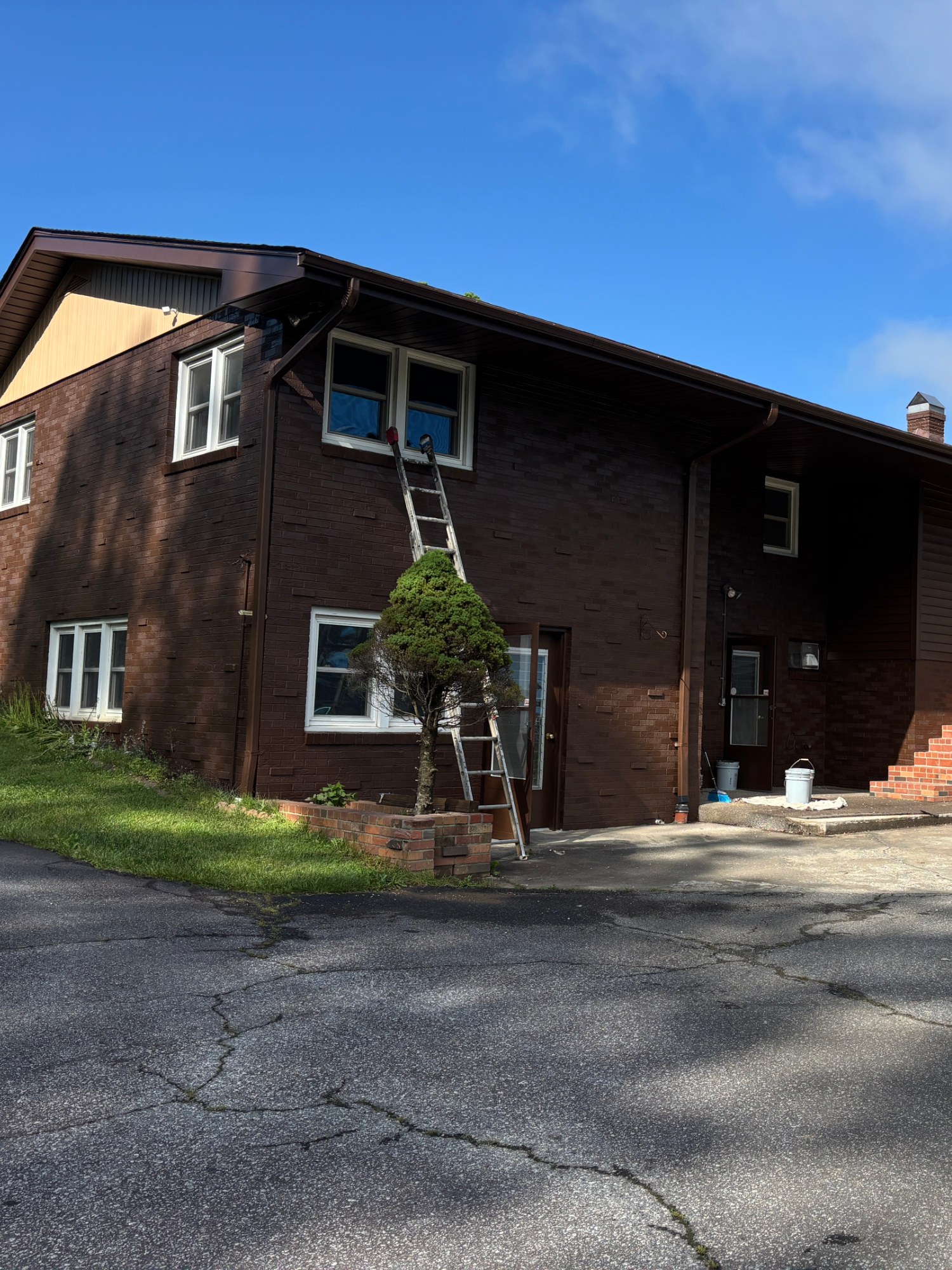 Two-story brick home exterior painting with fresh trim