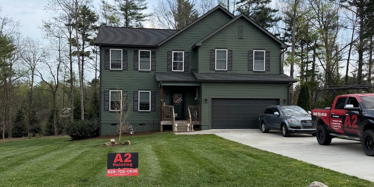 Two-story green home exterior painting with A2 Painting yard sign