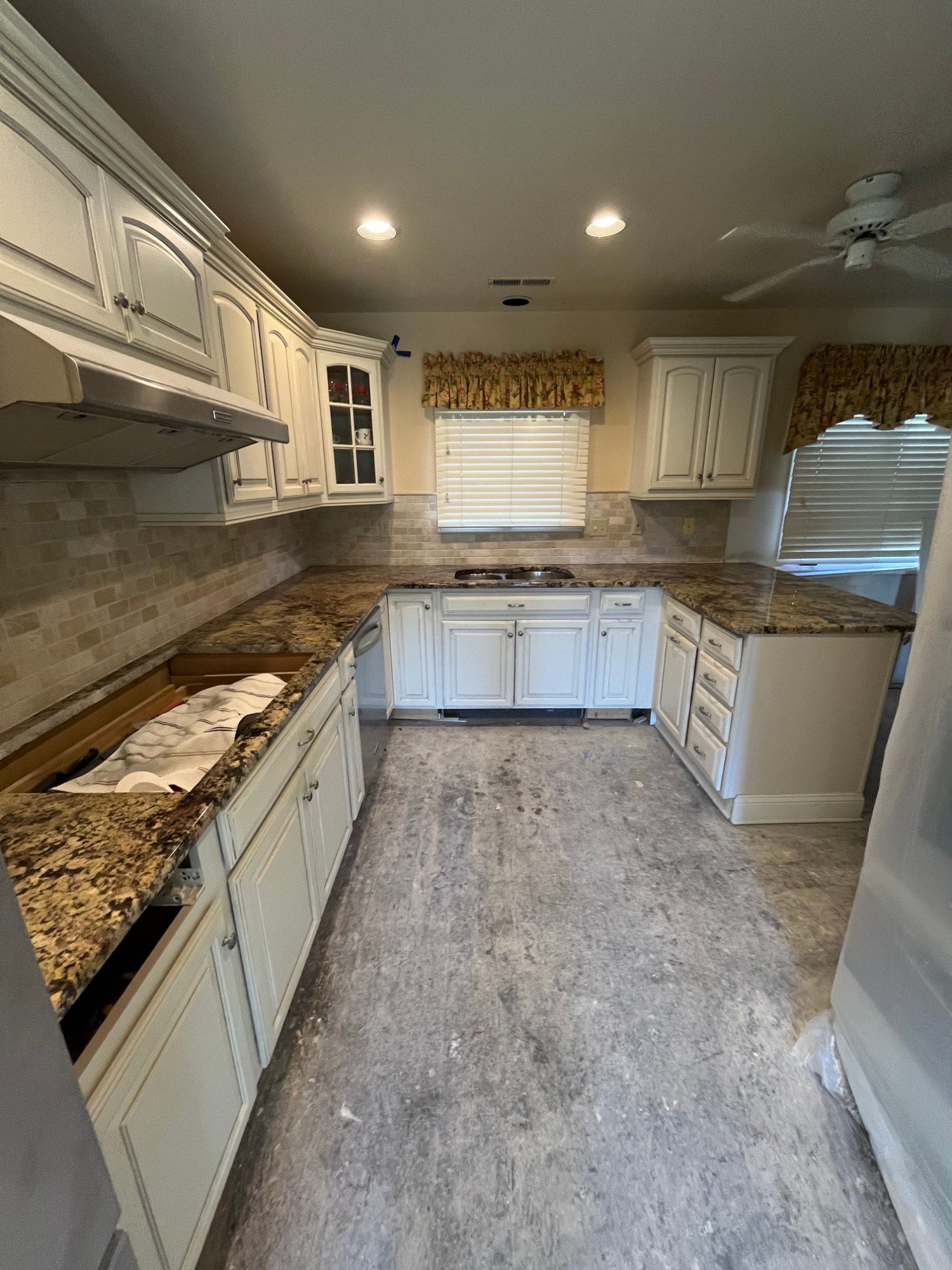 Large kitchen with white cabinets and granite counters freshly painted